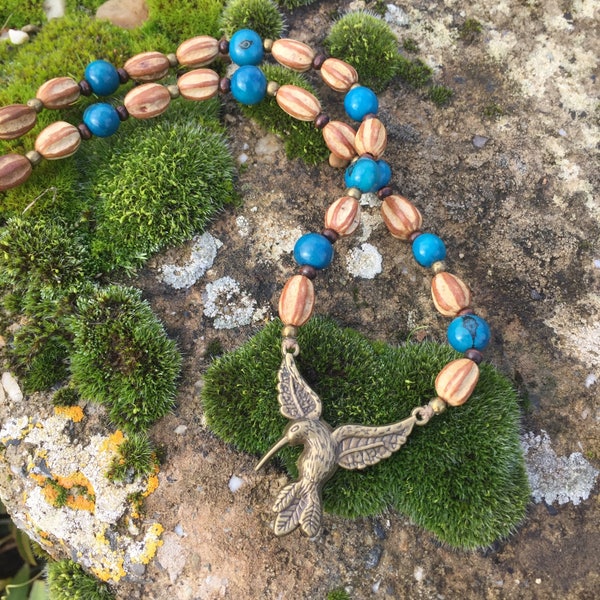 Collier ethnique en graines Santa Barbara et acai turquoise - colibri en métal couleur bronze