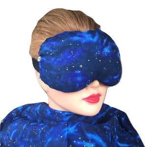May include: A blue sleep mask with a galaxy print. The mask is made of soft fabric and has an adjustable strap.