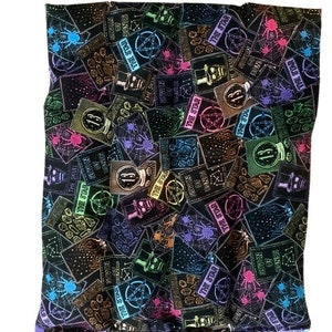 May include: A black fabric with a repeating pattern of colorful tarot cards. The cards feature various symbols and numbers, including the star, the skull, and the number 13.