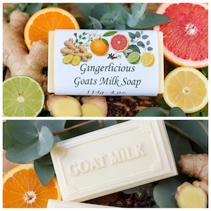 May include: A rectangular bar of Gingerlicious Goats Milk Soap with a white label featuring illustrations of ginger, orange, grapefruit, lime, and lemon. The label text reads Gingerlicious Goats Milk Soap 114g - 4 oz. A second bar is embossed with GOAT MILK.