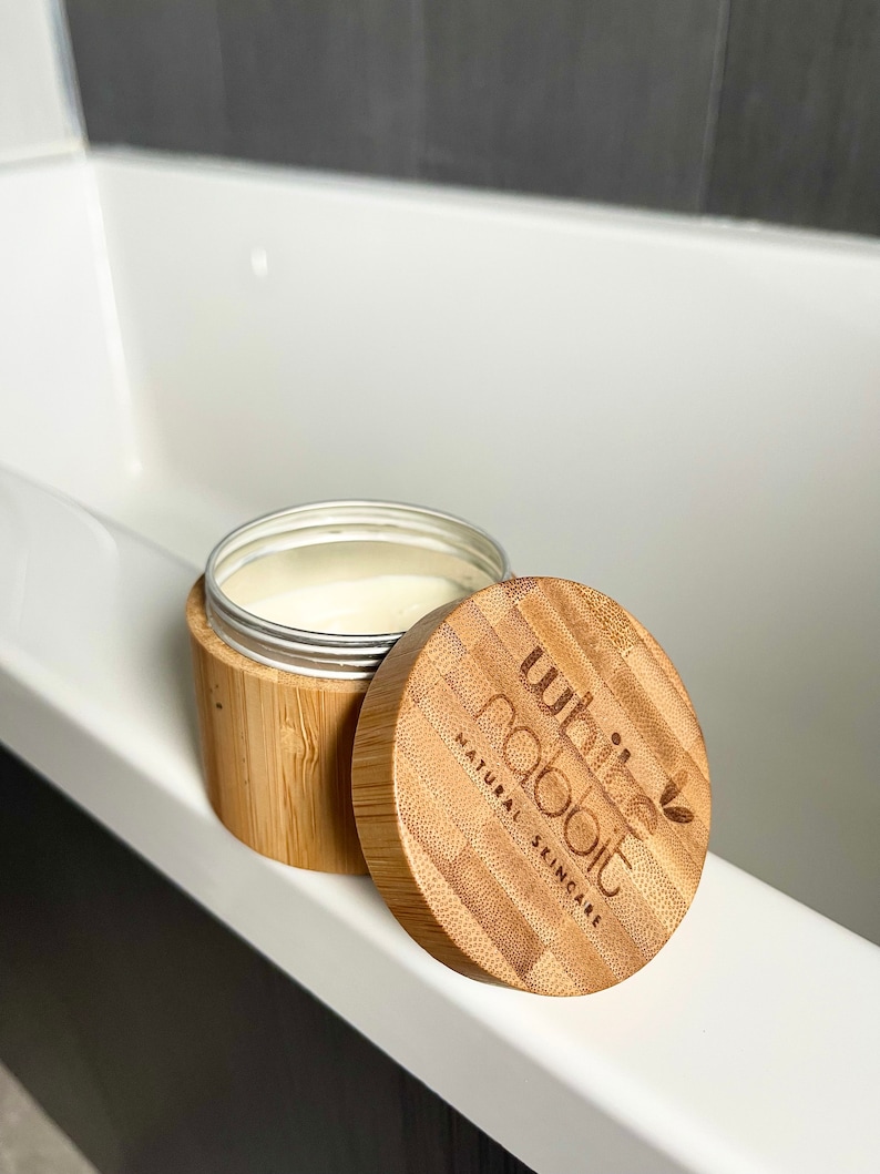 K&ouml;nnte beinhalten: Ein wei&szlig;es, h&ouml;lzernes Gef&auml;&szlig; mit Deckel. Das Gef&auml;&szlig; ist mit "white rabbit natural skincare" beschriftet.