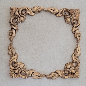 May include: Four gold-coloured ornate corner pieces for a picture frame or other decorative project.