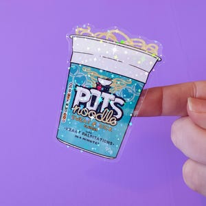 May include: A clear sticker with a glittery finish depicting a cup of instant noodles. The cup is blue and white with the text "POTS noodle" and "SWEAT & SICK FLAVOURED with HEART PALPITATIONS. 90g IN 6 MINUTES."