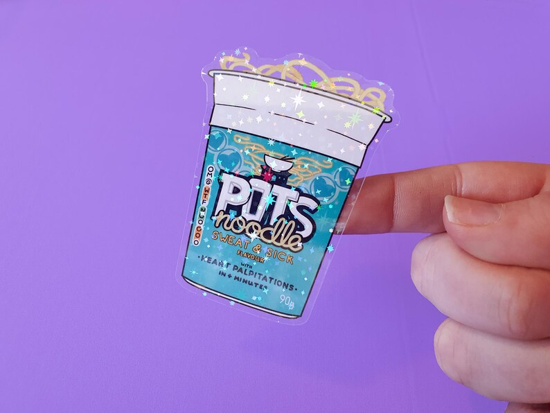 May include: A clear sticker with a glittery finish depicting a cup of instant noodles. The cup is blue and white with the text "POTS noodle" and "SWEAT & SICK FLAVOURED with HEART PALPITATIONS. 90g IN 6 MINUTES."