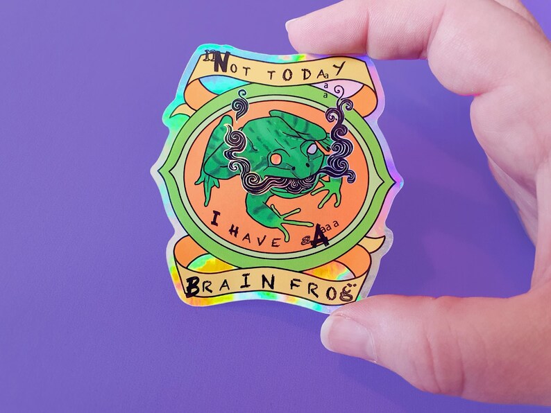 May include: A holographic sticker with a green frog with a mustache and the text "Not Today I Have A Brain Frog"