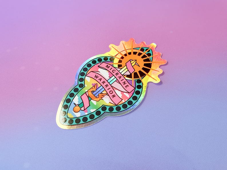 Pu&ograve; includere: Un adesivo olografico con uno schema di colori arcobaleno. L'adesivo presenta una spada con ali e un sole con un alone. Il testo sull'adesivo recita "Migraine Warrior".