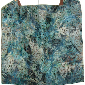May include: A square teal blue fabric with a brown leaf pattern. The fabric has a tie-dye effect and is made of a soft, lightweight material.