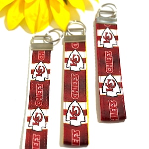 May include: Three red, white, and yellow keychains with the Kansas City Chiefs logo and the words "Chiefs" repeated on each keychain.