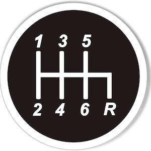 May include: A black and white circular sticker with a white gear shift pattern on a black background. The numbers 1, 2, 3, 4, 5, 6, and the letter R are displayed on the sticker.