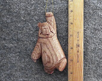 Hang in there bear ornament.  This artist created 5 inch original bear ornament has been hand carved from the wood of the Butternut tree.