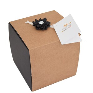 May include: A brown cardboard gift box with a black ribbon and a black flower with a rhinestone center. The box has a white tag attached with the text "Creations Crafts & Gifts".