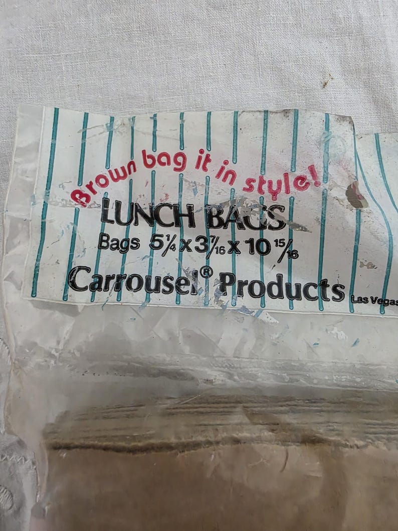 May include: A package of lunch bags with the text "Brown bag it in style!" and "LUNCH BAGS". The bags are 5 1/4 x 3 3/16 x 10 15/16 inches. The brand name "Carrousel Products" is also visible.