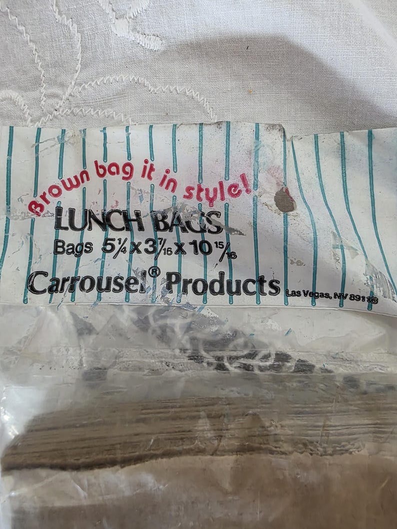 May include: A package of lunch bags with the text "Brown bag it in style!" and "LUNCH BAGS". The bags are 5 5/8 x 3 3/16 x 10 15/16 inches. The packaging has a blue and white striped design and the brand name "Carrousel Products".