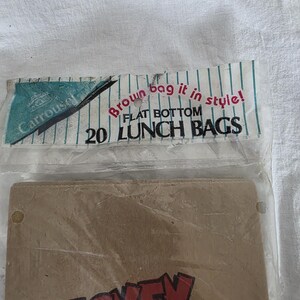 May include: A package of 20 flat-bottom lunch bags. The packaging includes the text "Brown bag it in style!" and "Carousel". The bags are brown with the word "Mickey" in red.