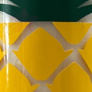 May include: A yellow pineapple-shaped tumbler with a green pineapple top. The tumbler has a white background with a yellow pineapple pattern.