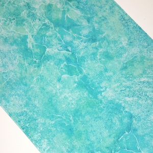 May include: A turquoise blue fabric with a marbled pattern. The fabric has a light green and white marbling effect.