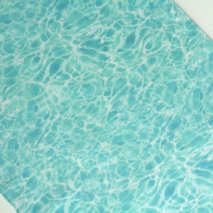 May include: A turquoise blue fabric with a rippling water pattern. The fabric has a white background with a light blue water pattern.