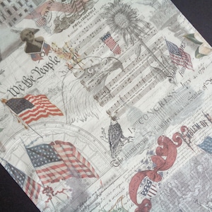 May include: A patriotic-themed fabric featuring American flags, eagles, musical notes, and historical text. The design incorporates red, white, and blue elements with the text "We the People" and "Emblem of Freedom".
