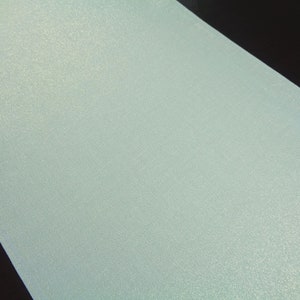 May include: A light blue, shimmery fabric with a subtle texture. The fabric has a slight sheen and a delicate, almost iridescent quality.