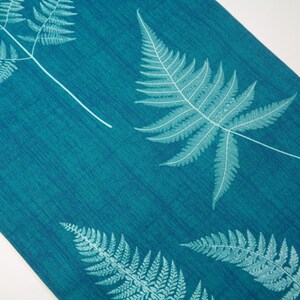 May include: Teal-colored fabric with a fern leaf pattern. The leaves are a lighter shade of teal and are arranged diagonally across the fabric. The fabric has a textured appearance.