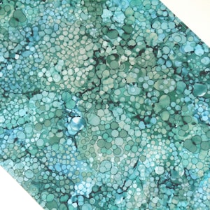 Peut inclure: Motif textile abstrait avec un motif de cercles superposés dans des tons de vert d'eau, turquoise et vert. Le motif a un effet aquarelle, avec des variations d'intensité de couleur créant de la profondeur et de la texture. Le fond est blanc.