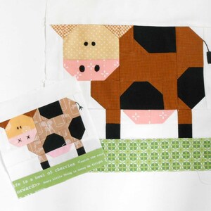 May include: Two patchwork fabric cows, one larger than the other, with black and brown spots. The larger cow is standing on a green patterned fabric strip. The smaller cow is on a white background with a text quote: "Life is a bowl of cherries.  Swatch the sunr.  Every little thing is gonna be alright.  Forward>>"