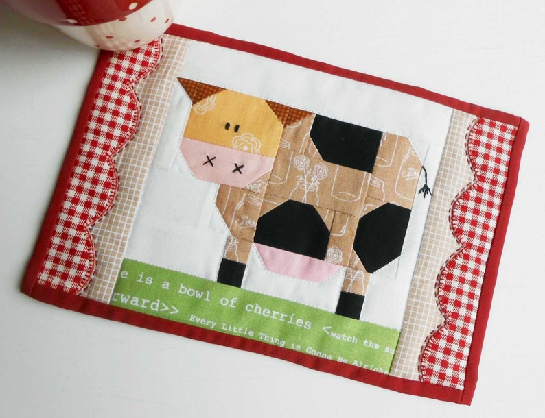 May include: A red, white, and black patchwork cow with a green background and the text "e is a bowl of cherries <watch the sun forward>> Every Little Thing is Gonna Be Alright".