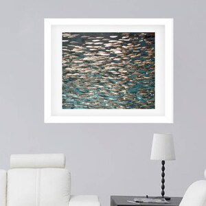 May include: A framed abstract art print featuring a teal and gold color scheme. The print depicts a swirling pattern of overlapping shapes, resembling water or fish scales.