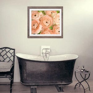 Op de afbeelding: Een ingelijste foto van een boeket perzikkleurige ranonkels. De bloemen zijn scherp en de achtergrond is wazig.