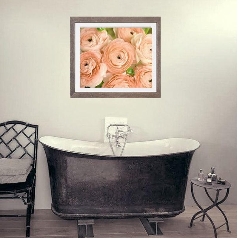 Op de afbeelding: Een ingelijste foto van een boeket perzikkleurige ranonkels. De bloemen zijn scherp en de achtergrond is wazig.