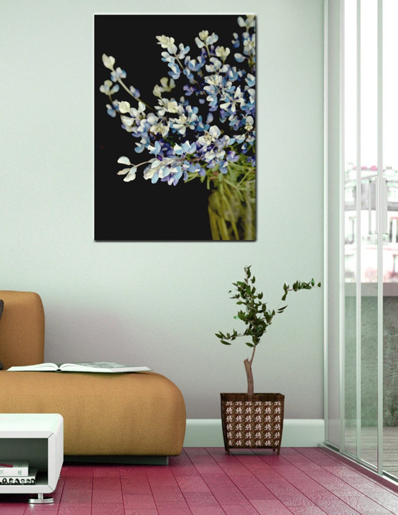 May include: A bouquet of blue and white flowers with green stems against a black background.