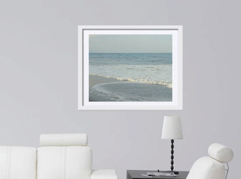May include: A framed photograph of a beach scene with blue water and white waves crashing on the shore.