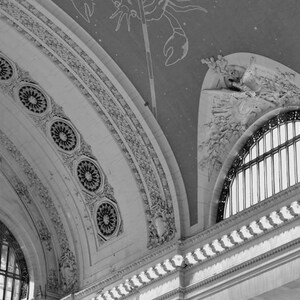 May include: Black and white photo of a vaulted ceiling with intricate decorative details. The ceiling features a series of arches and ornate carvings, creating a sense of grandeur and architectural beauty.