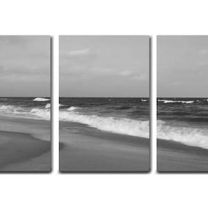 May include: A black and white photograph of a beach scene with waves crashing on the shore. The photo is split into three panels.