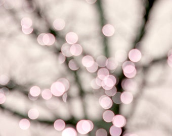 Op de afbeelding: Abstracte wazige achtergrond van een boom met onscherpe roze en witte lichten.