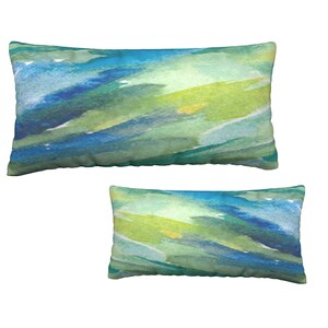 Könnte beinhalten: Zwei rechteckige Kissen mit einem abstrakten Aquarelldesign in Blautönen, Grüntönen und Gelb.
