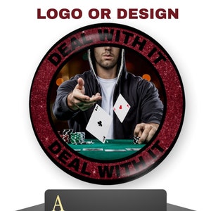 May include: A red and black round button with the text "Deal with it" in a circle around a man playing poker. The man is wearing a black hoodie and is holding a card in his hand. The button is on a white background.