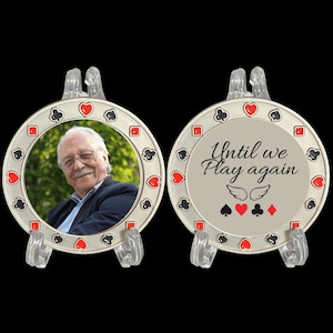 May include: A silver memorial coin with a photo of a man on one side and the text "Until we Play again" with playing card symbols and wings on the other side.