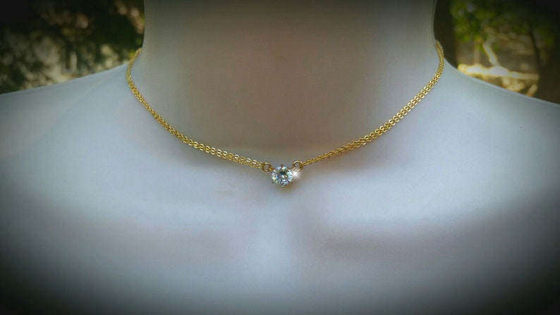 Puede incluir: Un collar de cadena dorada con un solo colgante de cristal.