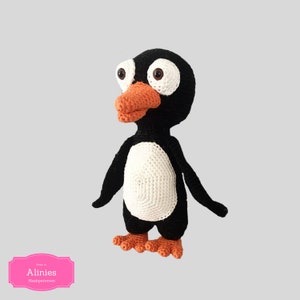 May include: A crocheted penguin toy with black and white body, orange beak and feet. The penguin has large, round eyes.