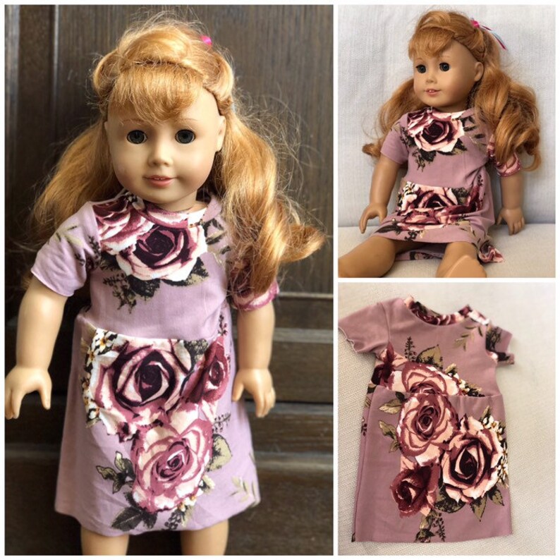 May include: A purple and pink floral dress with short sleeves for an 18-inch doll. The dress has a pocket on the front and a rose pattern.