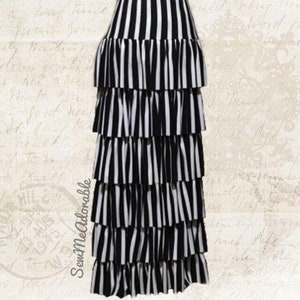 May include: A black and white striped skirt with multiple ruffles. The skirt is long and flowy. The text "ALL FABRIC PICTURED MAY NOT BE AVAILABLE" is at the bottom of the image.