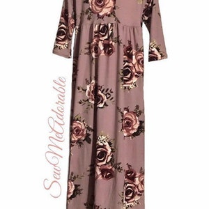 May include: A mauve long-sleeved dress with a floral print featuring pink and burgundy roses. The dress has a gathered waist and a flowing skirt.