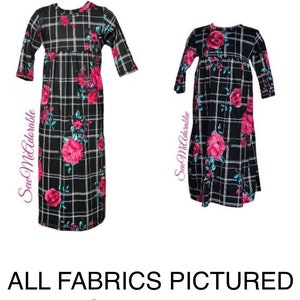 May include: Two black and white plaid dresses with pink floral designs. The dresses have 3/4 sleeves and a gathered waist.