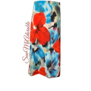 May include: A long, flowing skirt with a colorful floral print. The skirt features a mix of red, blue, and white flowers on a light gray background.