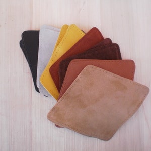 May include: A set of nine leather swatches in various shades of brown, tan, and yellow. The swatches are arranged in a fan shape, with the darkest shade at the bottom and the lightest shade at the top.