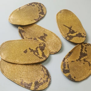 以下が含まれることがあります： 蛇柄の茶色と金色の革製のヒールパッドが6つあります。