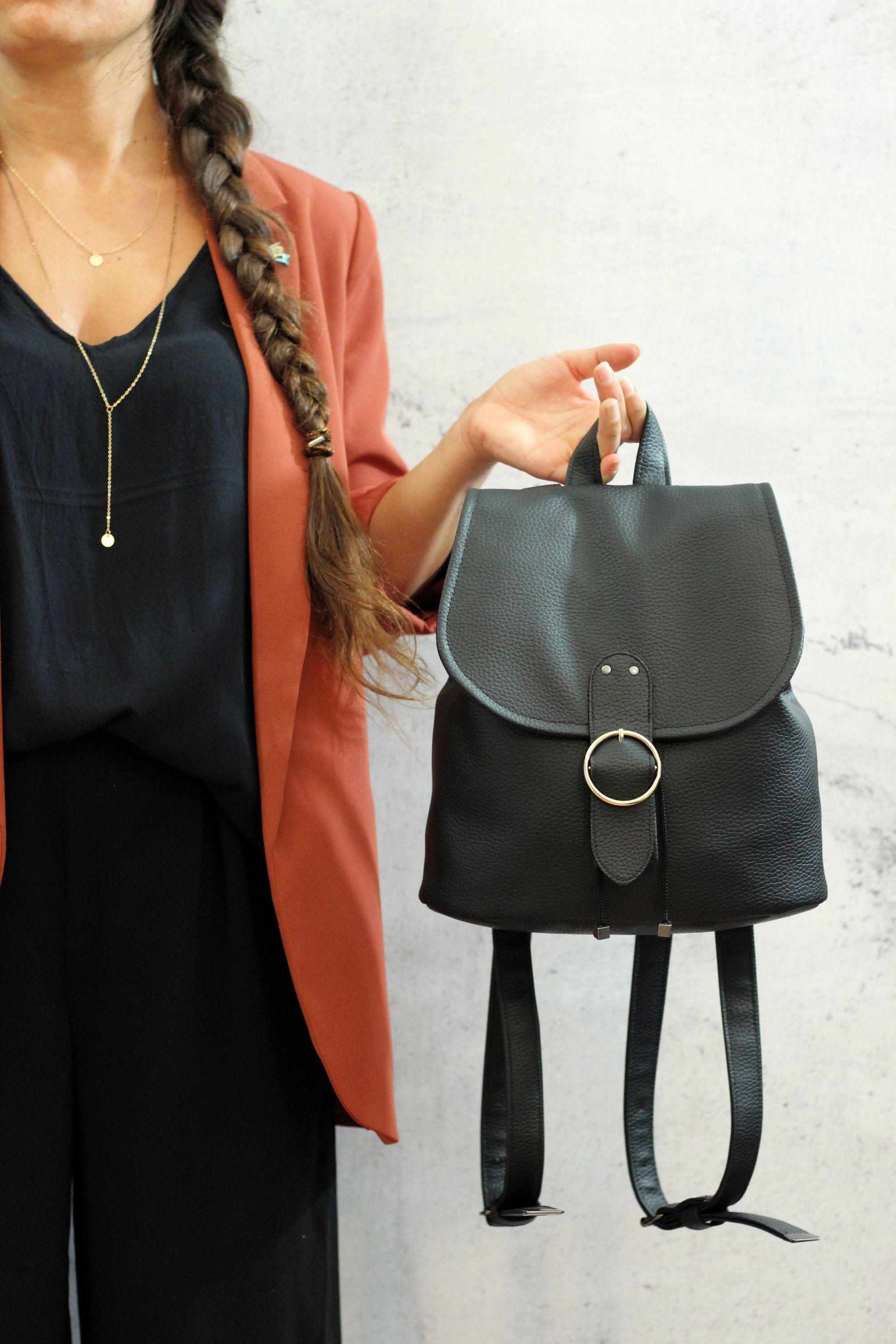 Black backpack with round gold closure. Vegan bucket backpack.