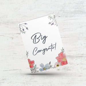 May include: A white card with a floral border and the text "Big Congrats!" in black script.