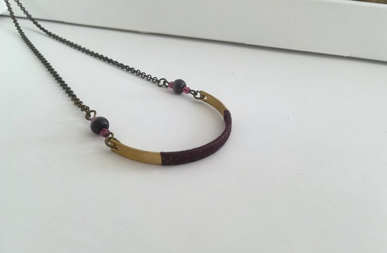 Long boho style necklace with dark bronze chain and gold half moon pendant decorated with grape silk thread round beads and glass beads